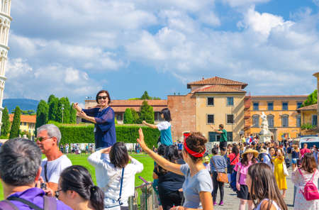Pisa, Italy, September 14, 2018: Tourists traveler caucasian and asian people are posing, having...