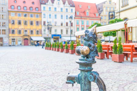 Wroclaw, Poland, May 7, 2019: Dwarf is sitting on street water tap on Rynek Market Square, famous bronze miniature gnome with hat sculpture is a symbol of Wroclaw in old historical city centreのeditorial素材