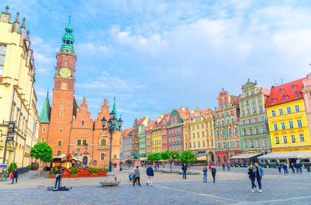 Wroclaw, Poland, May 7, 2019: Row of colorful buildings with multicolored facade, Old Town Hall and people walking on Rynek Market Square with cobblestone street in old historical city centreのeditorial素材