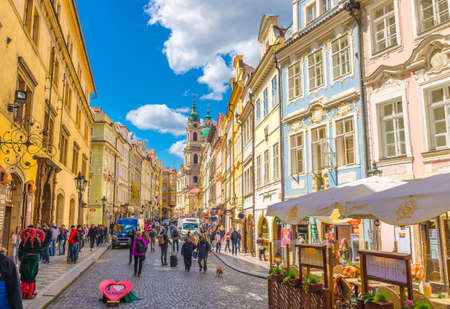 Prague, Czech Republic, May 13, 2019: people walking down street in Lesser Town, buildings with old colorful facades, Church of Saint Nicholas is Baroque catholic church backgroundのeditorial素材