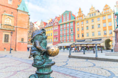 Wroclaw, Poland, May 7, 2019: Dwarf is sitting on street water tap on Rynek Market Square, famous bronze miniature gnome with hat sculpture is a symbol of Wroclaw in old historical city centreのeditorial素材