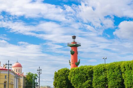 Rostral Column on Strelka Arrow of Vasilyevsky Island with green trees in Saint Petersburg Leningrad city, blue sky white clouds background, Russiaの写真素材