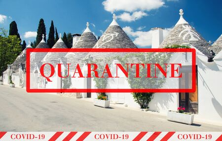Quarantine in Italy. Town of Alberobello, village with Trulli houses. No travel and lockdown concept. Coronavirus outbreak Covid-19 pandemic concept. Canceled tourist vacation. Yellow black tape.の写真素材