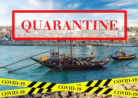 Quarantine in Portugal. Wooden boats with wine barrels on Douro river in Porto. No travel and lockdown concept. Coronavirus outbreak Covid-19 pandemic concept. Canceled tourist vacation. Barrier tape.の写真素材