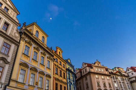 Row of buildings with colorful facades in Prague Old Town Stare Mesto historical city centre on Old Town Square Staromestske namesti in evening, blue sky and moon background, Bohemia, Czech Republicの写真素材
