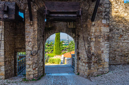 Brescia, Italy, September 11, 2019: Stone wall with merlons and drawbridge Gate of medieval Castle of Brescia or Castello di Brescia or Falcon of Italy, historical city centre, Lombardyのeditorial素材