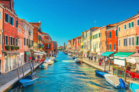 Murano, Italy, September 14, 2019: island, bridge across water canal, boats, motor boats, colorful traditional buildings, Venetian Lagoon, Veneto Region, San Michele in Isola Catholic churchのeditorial素材