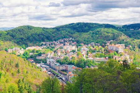 Top aerial panoramic view of Karlovy Vary Carlsbad spa town with colorful beautiful buildings, Tepla river and hills of Slavkov Forest with green trees, West Bohemia, Czech Republicの写真素材