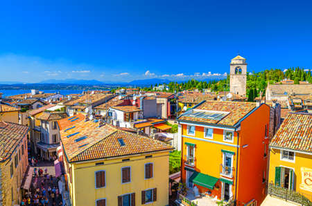 Sirmione, Italy, September 11, 2019: aerial panoramic view of Sirmione town historical centre, multicolored colorful buildings with red tiled roofs, blue sky background, Lombardy, Northern Italyのeditorial素材