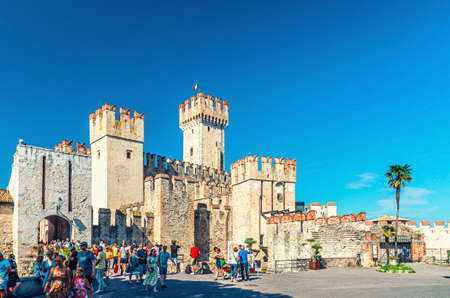 Sirmione, Italy, September 11, 2019: Scaligero Castle Castello fortress from Scaliger era, historical center of Sirmione town on Garda lake, medieval castle with stone towers brick walls, Lombardyのeditorial素材