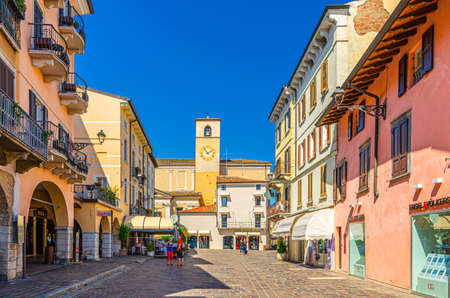 Desenzano del Garda, Italy, September 11, 2019: bell and clock tower of Duomo di Santa Maria Maddalena Cathedral catholic church building in old historical town centre, blue sky background, Lombardyのeditorial素材