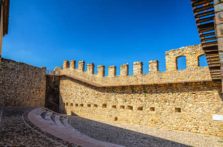 Desenzano del Garda, Italy, September 11, 2019: courtyard, spiral staircase and stone brick walls with merlons of medieval castle Castello di Desenzano, blue sky backgroundのeditorial素材