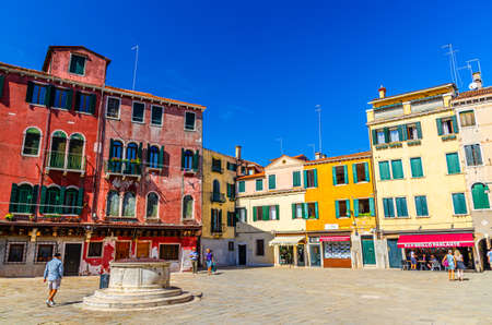 Venice, Italy, September 13, 2019: Campo San Sin square with stone well and old colorful buildings in historical city centre sestiere of San Polo, blue sky background, Veneto Regionのeditorial素材