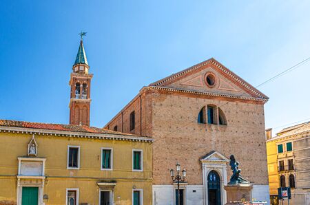 Parrocchia di San Giacomo Apostolo catholic church with bell tower in historical centre of Chioggia town, blue sky background in summer day, Veneto Region, Northern Italyの写真素材