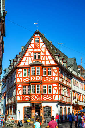 Mainz, Germany, August 24, 2019: Traditional german houses with typical wooden facade fachwerk style and tourists people walking down cobblestone street in historical medieval town centreのeditorial素材
