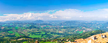 Watercolor drawing of Aerial top panoramic view of landscape with valley, green hills, fields and villages of Republic San Marino suburban with blue sky white clouds. View from San Marino fortress.の写真素材