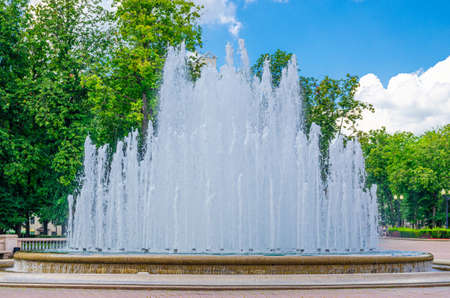 Water fountain near Opera and Ballet Theatre building in park in Trinity Hill district of Minsk city historical centre, blue sky white clouds in sunny summer day, Republic of Belarusの写真素材
