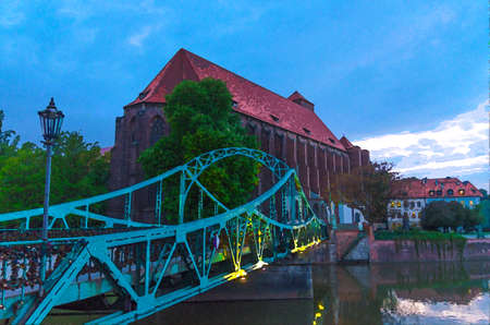 Watercolor drawing of Roman Catholic parish Saint Mary church NMP on Sand island Wyspa Piasek, view through arch of Tumski bridge in old town historical city center of Wroclaw, evening view, Polandの写真素材
