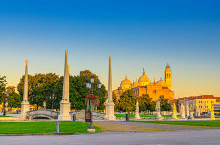 Padua cityscape with statues near bridge across small canal on Piazza Prato della Valle square in historical city centre, Abbey of Santa Giustina church, Padova town, Veneto Region, Italyの写真素材