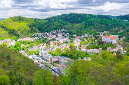 Top aerial panoramic view of Karlovy Vary Carlsbad spa town with colorful beautiful buildings, Tepla river and hills of Slavkov Forest with green trees, West Bohemia, Czech Republicの写真素材