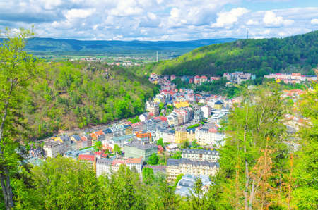Karlovy Vary Carlsbad historical city centre top aerial view with colorful beautiful buildings, Slavkov Forest hills with green trees and Ore Mountain range background, West Bohemia, Czech Republicの写真素材