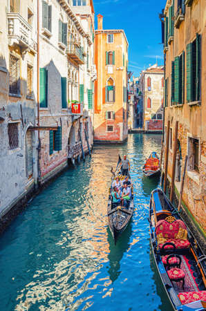 Venice, Italy, September 13, 2019: gondolier on gondola traditional boat with tourists people sailing in narrow water canal between old colorful buildings in historical city centre, Veneto Regionのeditorial素材