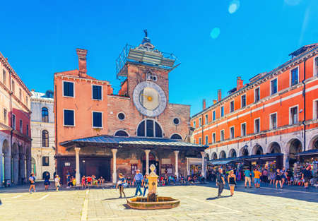 Venice, Italy, September 13, 2019: people tourists walking down Campo San Giacomo di Rialto square with Chiesa church building in historical city centre, blue sky background, Veneto Regionのeditorial素材