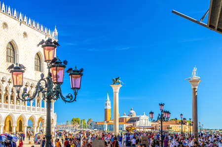 Venice, Italy, September 13, 2019: people walking down Piazza San Marco St Marks Square with street light and Palazzo Ducale, San Giorgio Maggiore island with Campanile San Giorgio backgroundのeditorial素材