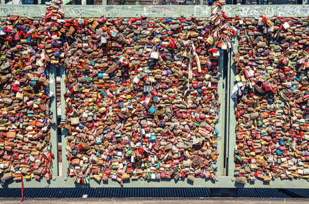 Cologne, Germany, August 23, 2019: many love locks padlocks on railing of Hohenzollern steel bridge or Hohenzollernbrucke across Rhine river, symbol of loveのeditorial素材