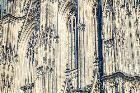 Close-up view of Cologne Cathedral Catholic Church gothic style building wall facade with ornaments, moldings stucco work and stained glass windows, North Rhine-Westphalia, Germanyの写真素材