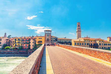 The Ponte Pietra Stone Bridge, Pons Marmoreus, Roman arch bridge across Adige River, buildings on bank, Duomo di Verona bell tower Campanile in historical city center, Veneto Region, Northern Italyの写真素材