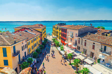 Sirmione, Italy, September 11, 2019: aerial panoramic view of historical center pedestrian street Castle square piazza Castello, multicolored colorful buildings with red tiled roofs and Garda lakeのeditorial素材