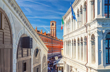 Venice, Italy, September 13, 2019: Palazzo dei Camerlenghi palace building and bell tower campanile in historical city center in sunny summer day with blue sky, view from Rialto Bridge. Veneto Regionのeditorial素材