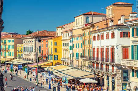 Verona, Italy, September 12, 2019: Row of old colorful multicolored buildings on Piazza Bra square in historical city center, cafes and restaurants with tents and walking tourists, aerial viewのeditorial素材