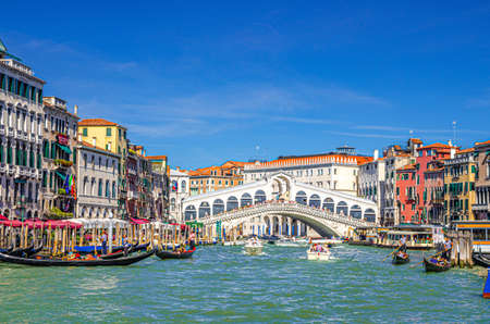 Venice, Italy, September 13, 2019: cityscape with Rialto Bridge across Grand Canal waterway, Venetian architecture colorful buildings, gondolas, boats, vaporettos docked and sailing Canal Grandeのeditorial素材