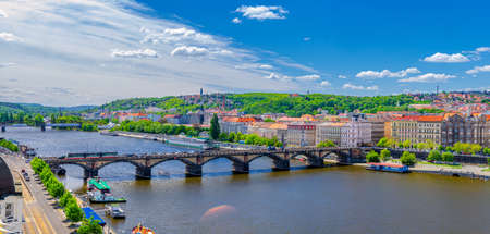 Aerial panoramic view of Prague city historical center with Smichov district, Palackeho most bridge, row of buildings along Vltava river, blue sky white clouds background, Bohemia, Czech Republicの写真素材