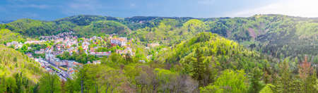 Karlovy Vary city aerial panoramic view with row of colorful multicolored buildings and spa hotels in historical city center. Panorama of Karlsbad town and Slavkov Forest mountains, Czech Republicの写真素材