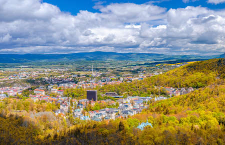 Karlovy Vary city aerial panoramic view with row of colorful multicolored buildings and spa hotels in historical city center. Panorama of Karlsbad town and Ore mountain range in autumnの写真素材
