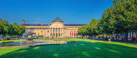 Wiesbaden, Germany, August 24, 2019: panorama of Kurhaus or cure house spa and casino building and Bowling Green park with grass lawn, trees alley and pond with fountain in historical city centerのeditorial素材