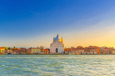 Chiesa del Santissimo Redentore catholic church and row of buildings on fondamenta embankment of Giudecca island canal in Venetian Lagoon, sunset view from Venice city, Veneto region, Northern Italyの写真素材