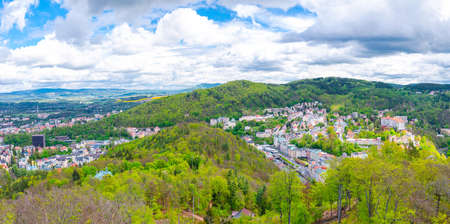Karlovy Vary city aerial panoramic view with row of colorful multicolored buildings and spa hotels in historical city center. Panorama of Karlsbad town and Slavkov Forest hills, Czech Republicの写真素材