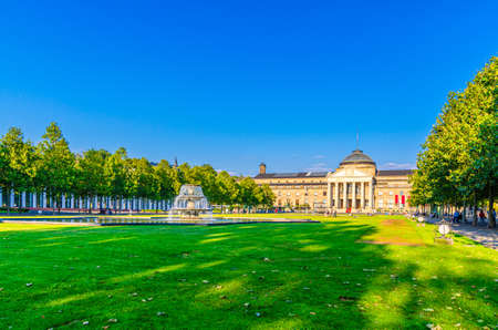 Wiesbaden, Germany, August 24, 2019: Kurhaus or cure house spa and casino building and Bowling Green park with grass lawn, trees alley and pond with fountain in historical city center, State of Hesseのeditorial素材
