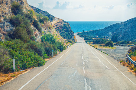 Asphalt seaside road among hills leading to Mediterranean sea, Cyprusの写真素材