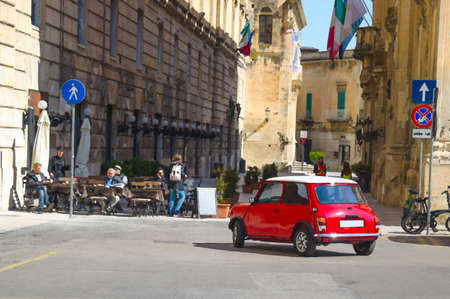 Watercolor drawing of vintage retro small red car with man driver inside ride to the central square for exhibition, Puglia Apulia region, Southern Italyの写真素材