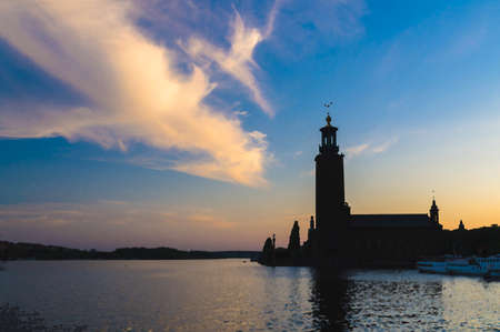 Watercolor drawing of Silhouette of Stockholm City Hall Stadshuset tower building of Municipal Council and venue of Nobel Prize on Kungsholmen Island at sunset, dusk, blue sky background, Swedenの写真素材