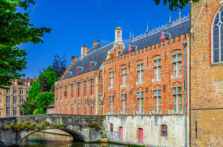Blinde-Ezelbrug stone bridge across Groenerei Green Canal water of Reie river in Brugge old town, Brugse Vrije Liberty of Bruges Renaissance architecture style building in Bruges city center, Belgiumの写真素材