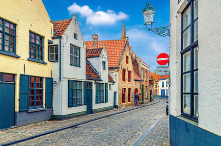 Bruges cityscape with empty narrow cobblestone street, colorful buildings, traditional houses in Brugge city historical centre, Bruges old town Steenstraat quarter, West Flanders province, Belgiumの写真素材
