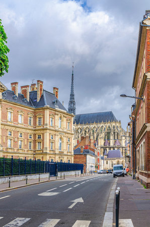 Street view of Palace of Justice Palais Cour d'Appel and Amiens Cathedral buildings in historical city centre, cloudy sky background, vertical view, Somme department, Hauts-de-France Region, Franceの写真素材