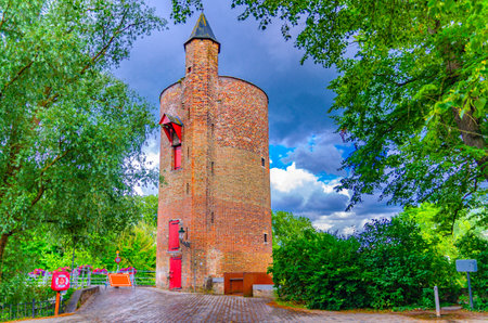 Poertoren en Minnewaterbrug Gunpowder Tower brick building near Lovers' Bridge in Brugge city historical centre, Bruges old town quarter district, West Flanders province, Flemish Region, Belgiumの写真素材