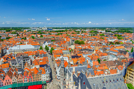 Bruges cityscape, aerial panoramic view of Bruges historical city center with old buildings red tiled roofs, color Flemish townhouses, Brugge old town quarters, West Flanders province, Belgiumの写真素材